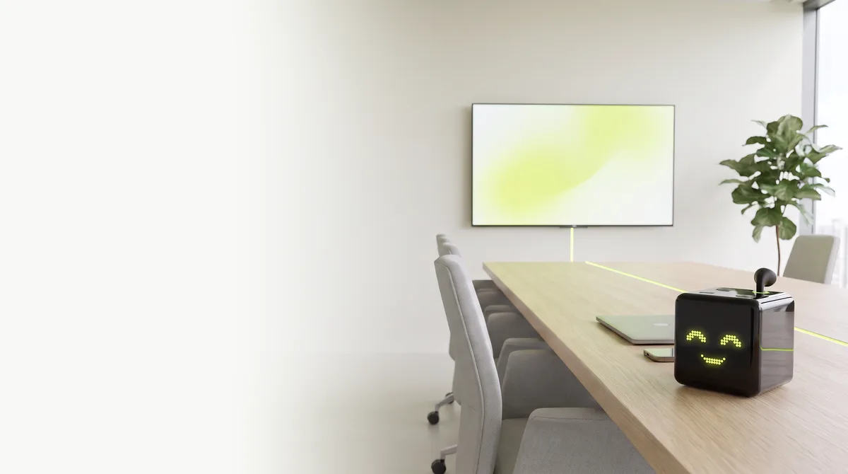 Antone, a black cube with a lime dot-matrix face, on a boardroom table and linked to the screen on the wall