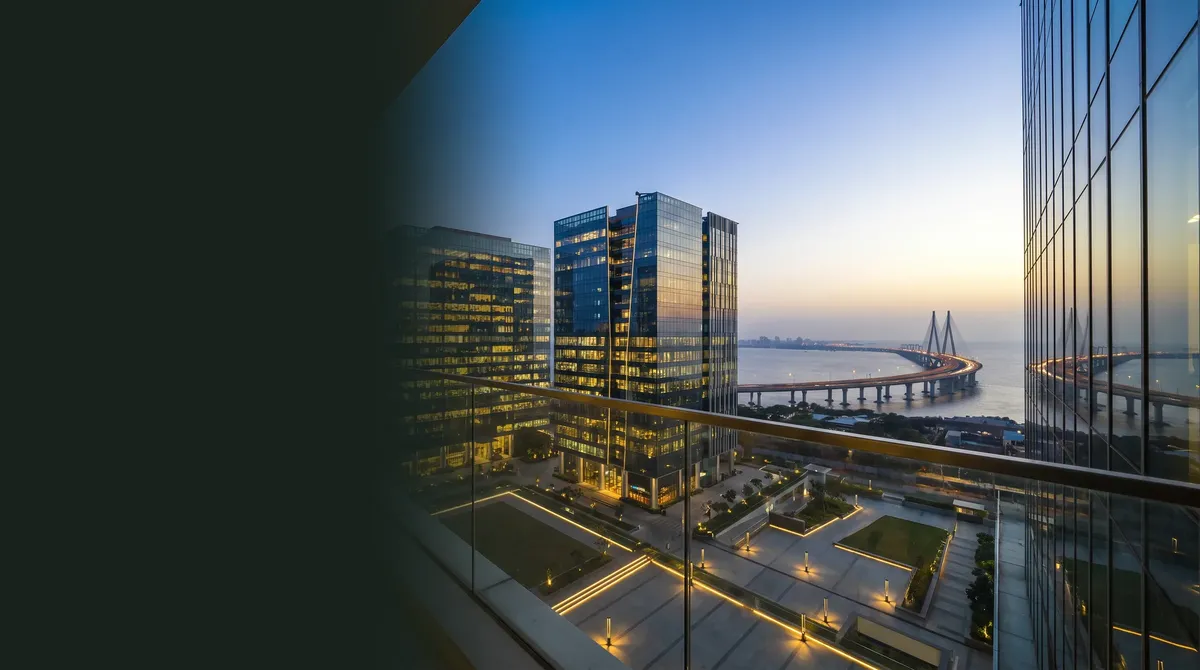 Mumbai at dusk from a glass office: towers, the sea link and the lights coming on